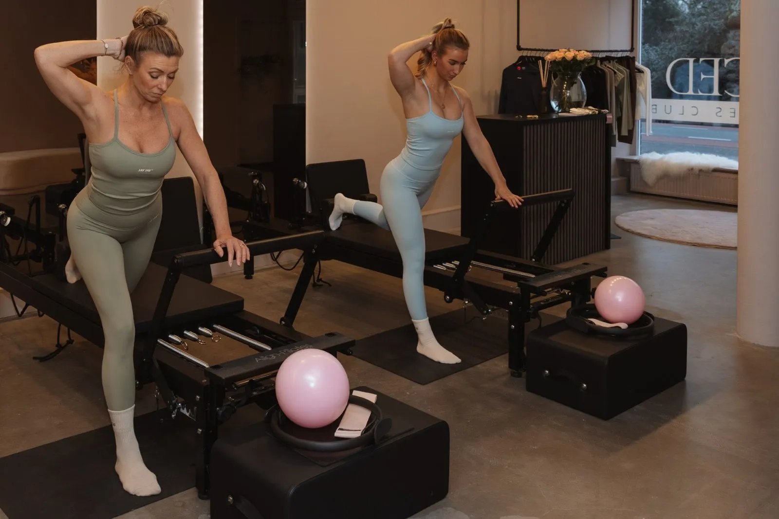 Twee vrouwen staan op de reformer en trainen hun benen
